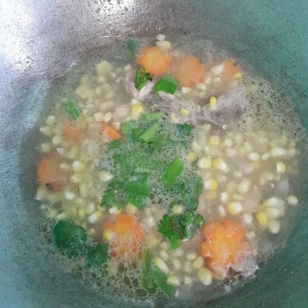 Tambahkan wortel, daun bawang, dan daun seledri. Aduk rata dan masak sampai wortel dan jagung lunak, tes rasa siap disajikan.