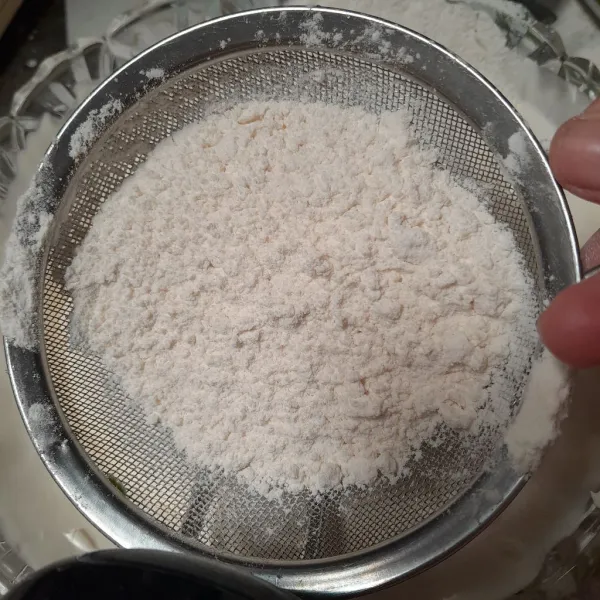 Masukkan tepung terigu dan tepung maizena sambil diayak.