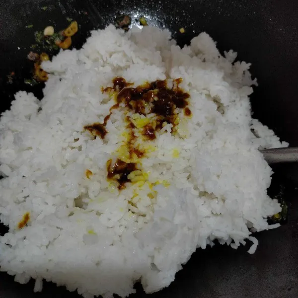 Tambahkan nasi dan bumbu instan nasi kuning, aduk hingga rata.