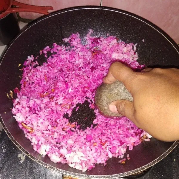Tambahkan nasi putih kemudian aduk rata dan tekan - tekan dengan menggunakan coet agar buah naga menyatu dengan nasi.