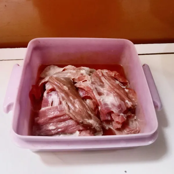 Cuci bersih daging sapi yang sudah diiris untuk dendeng, kemudian beri perasan jeruk nipis.