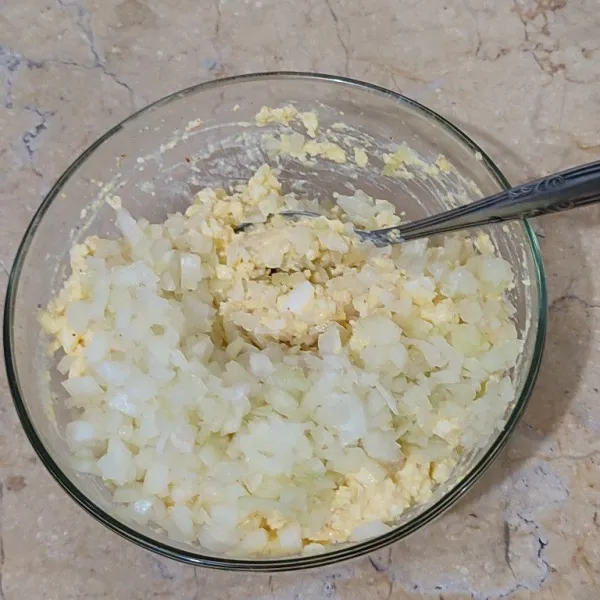 Cincang bawang bombay hingga potongan kecil (catatan: semakin kecil potongan bawang, semakin halus saus tartar yang dihasilkan) dan campurkan bawang bombay ke campuran telur.