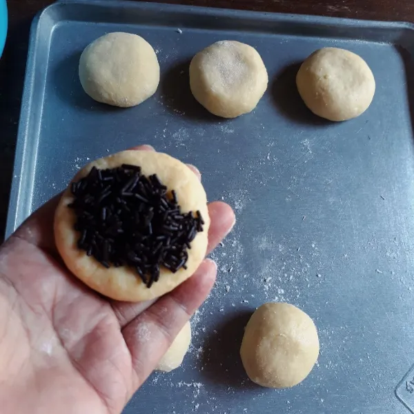 Kempiskan adonan, bagi menjadi 12 buah, bulatkan. Pipihkan dan isi dengan meses, bulatkan kembali dan bentuk agak pipih. Diamkan selama 15 menit.