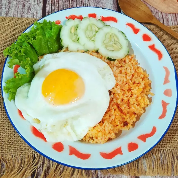 Sajikan nasi goreng merah tanpa saos dengan pelengkapnya.