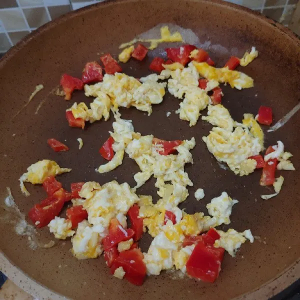 Masukkan 1 butir telur, aduk cepat dan masukkan potongan paprika. Masak sampai tercampur rata.