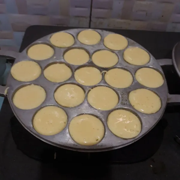 Panaskan cetakan dengan api kecil dan olesi tipis margarin. Tuang 1 sdm adonan, tutup dan masak hingga sisi bawah matang.