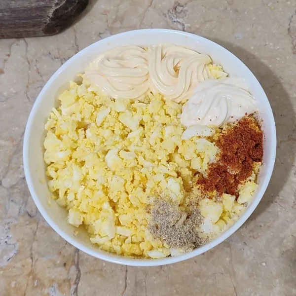 Tambahkan mayonaise jepang, mayonaise, garam, lada, susu full cream, kental manis, dan perasan lemon pada telur rebus.