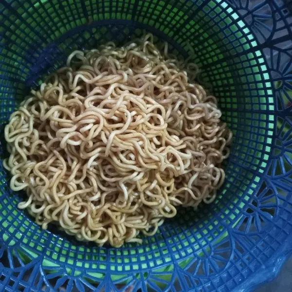 Rebus mie dan angat, tuangkan kecap secukupnya, aduk hingga rata.