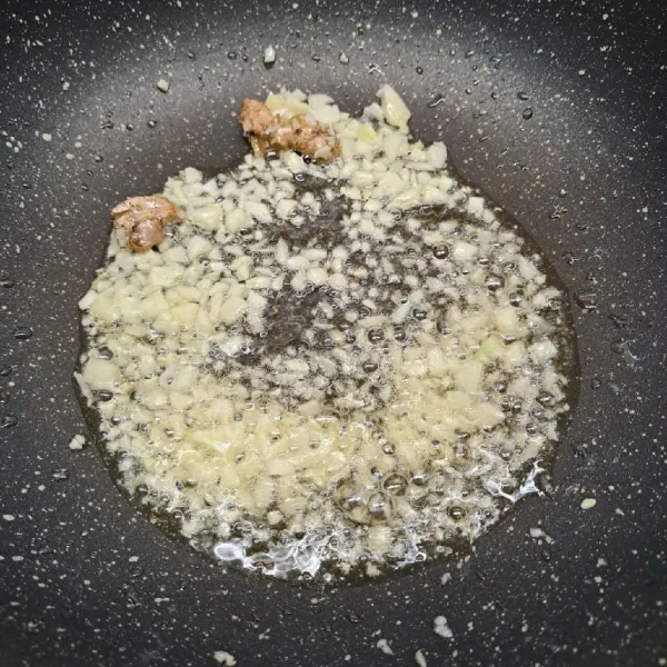 Panaskan minyak goreng dan minyak wijen. Tumis bawang putih dan jahe sampai harum dan layu.
