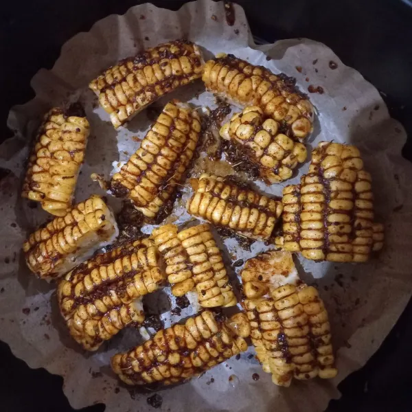Oleskan bumbu di atas jagung hingga merata. Kemudian panggang di dalam air fryer dengan suhu sekitar 180 derajat selama 10 menit. Oles lagi dan panggang lagi selama lima menit.