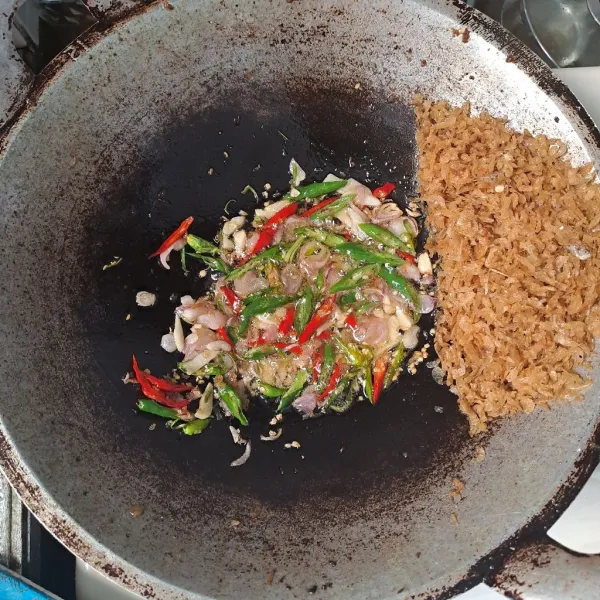 Sisihkan ebi ke pinggir wajan. Tumis bawang merah, bawang putih hingga harum. Masukkan cabe hijau dan merah.