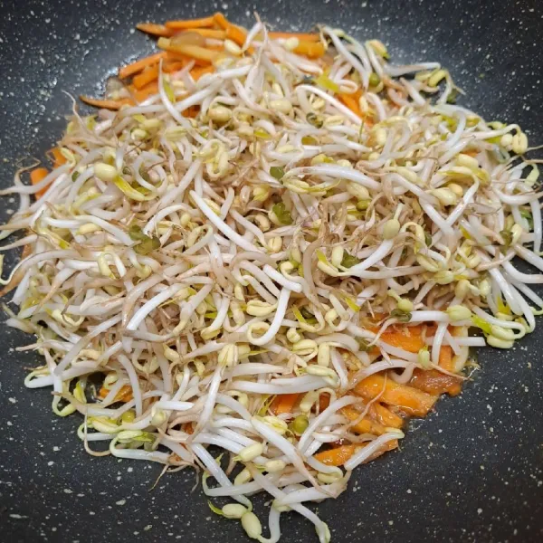 Masukkan tauge, aduk rata dan masak sampai ½ matang sambil koreksi rasa sekali lagi.