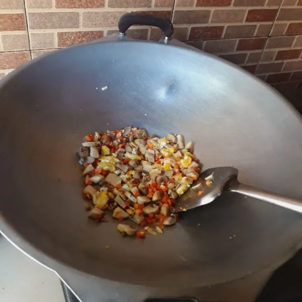 Masukkan bawang putih, wortel dan jamur, masak hingga matang dan wangi.