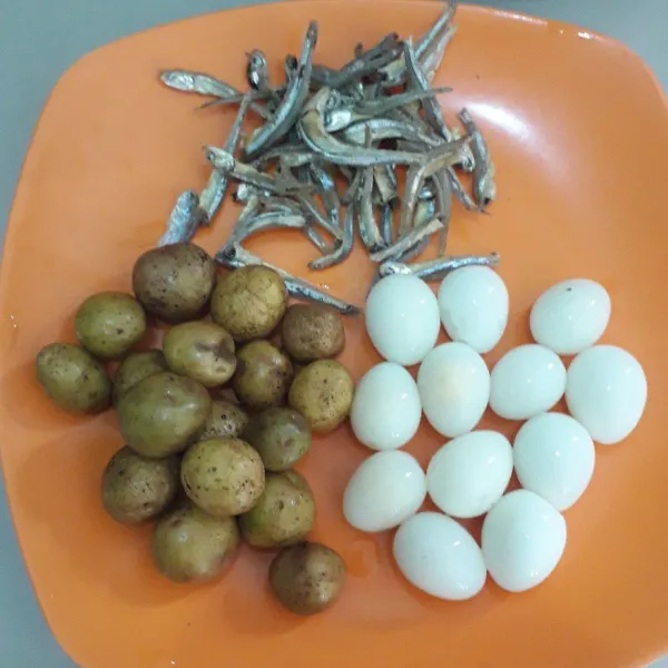 Rebus telur puyuh sampai matang lalu kupas. Cuci bersih kentang dan ikan teri.
