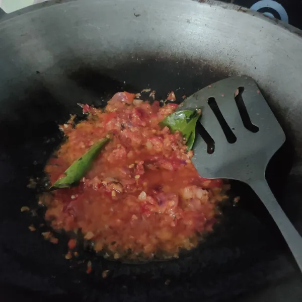 Tumis bumbu halus bersama lengkuas dan daun salam hingga harum dan matang.