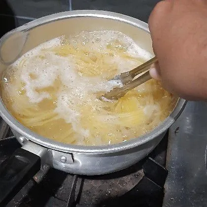 Rebus spaghetti dengan air mendidih dan sedikit minyak goreng hingga al dente, angkat dan tiriskan.