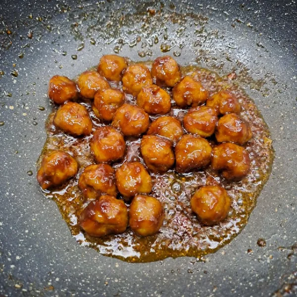 Masak sampai kuah menyusut dan terpisah bumbu dengan minyak. Matikan kompor. Tusuk menyerupai sate isi 3 biji bakso kerikil. Sajikan.