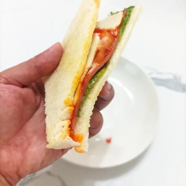 Potong sandwich menjadi 2 segitiga, sajikan.