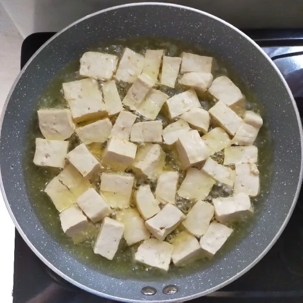 Panaskan minyak, kemudian goreng tahu hingga kuning keemasan.