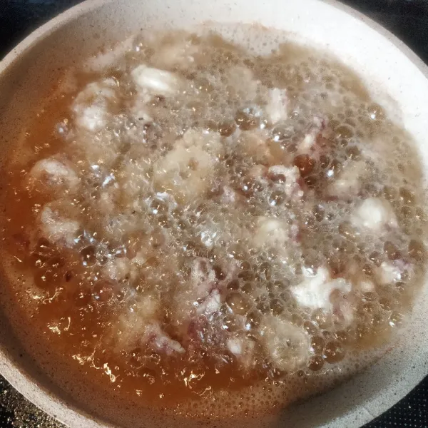 Goreng cumi dalam minyak panas hingga tepung pelapis kecoklatan.