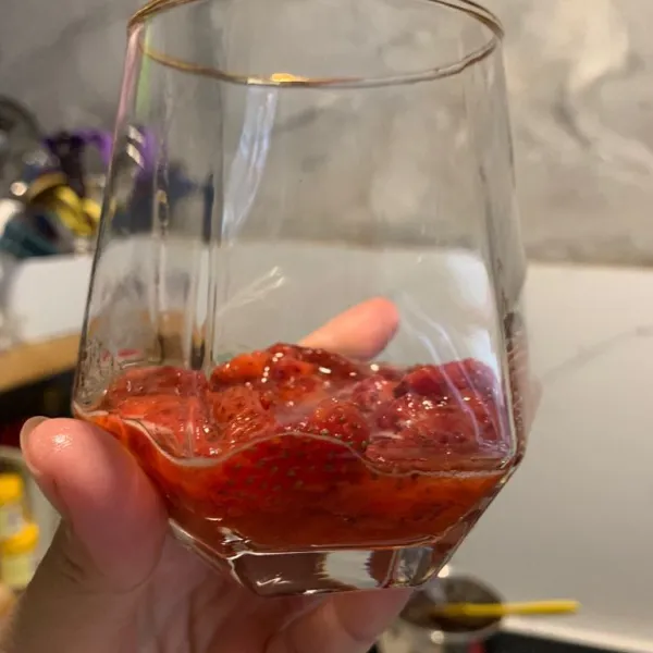 Hancurkan strawberry dengan ditekan menggunakan garpu. Tuang di dasar gelas.