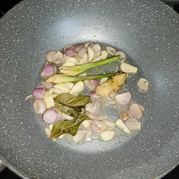 Tumis bawang merah, bawang putih, serai, lengkuas dan daun salam sampai harum.