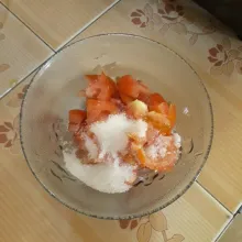 Tambahkan gula pasir lalu tekan-tekan dengan sendok hingga tercampur rata dengan tomat.