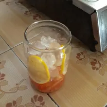 Tambahkan es batu dan beri irisan jeruk lemon di samping gelas.