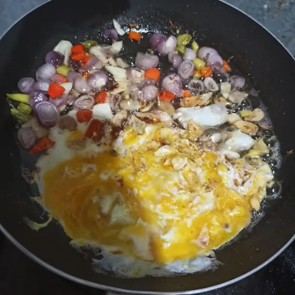 Sisihkan bawang merah, bawang putih dan cabe rawit ke pinggir. Lalu masukkan telur.