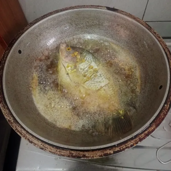goreng ikan dalam minyak yang sudah panas, pastikan ikan terendam minyak.