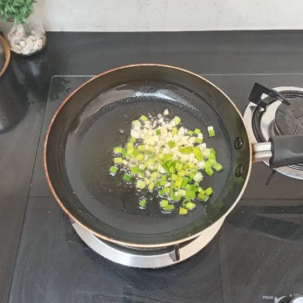 Panaskan 5 sdm minyak, tumis bawang putih dan bawang daun hingga layu.