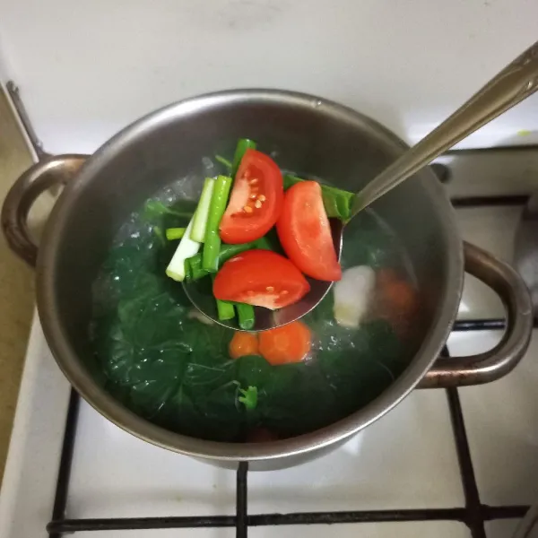 Masukkan irisan bawang daun dan tomat lalu masak hingga matang.