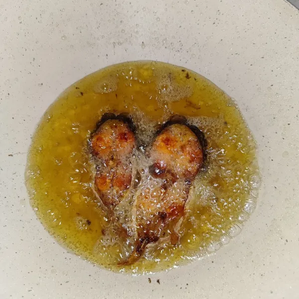 Kemudian panas kan minyak, lalu goreng ikan sampai kering dan berubah warna kecoklatan.