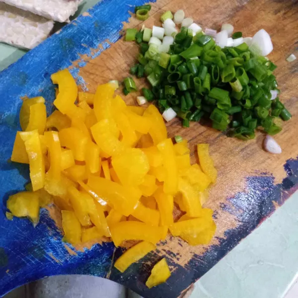 Potong-potong paprika kuning dan daun bawang.