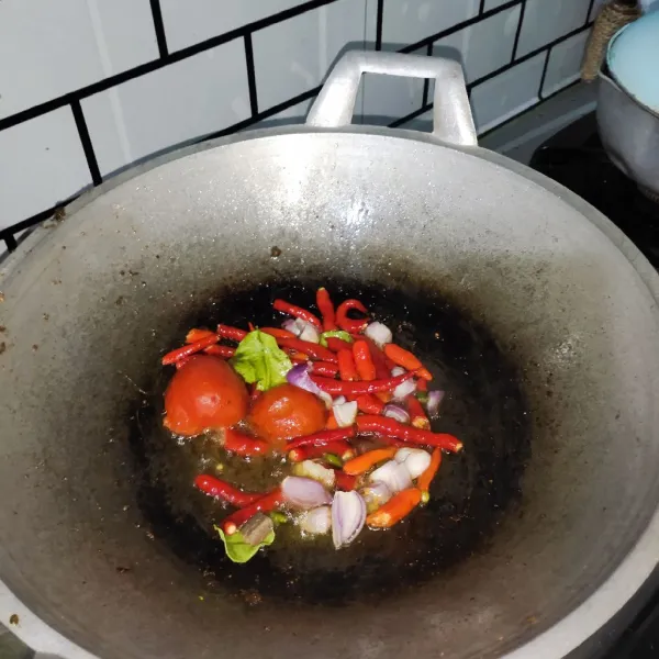 Panaskan minyak, pertama masukan kemiri terlebih dahulu setelah itu menyusul bawang, cabai, tomat, daun jeruk dan terasi.