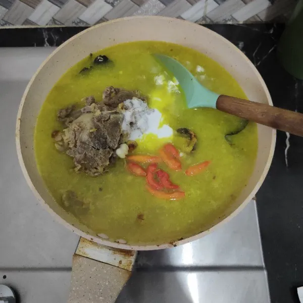 Tambahkan air, santan dan cabe rawit masak hingga mendidih.