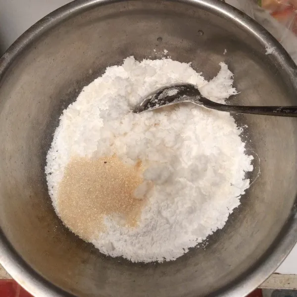 Masukkan kelapa parut, gula dan garam ke wadah tepung. Aduk hingga tercampur rata.