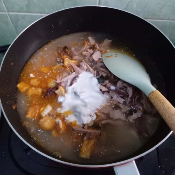 Masukkan ikan cakalang suwir, tahu, air dan santan instan. Aduk rata, bumbui garam, gula, kunyit bubuk dan kaldu bubuk.