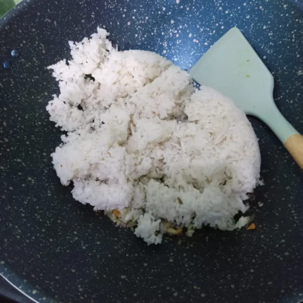 Masukkan nasi, aduk-aduk hingga tak ada yang menggumpal.