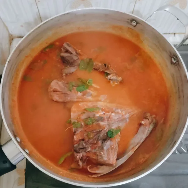 Setelah mendidih masukkan kapala ikan tongkol, daun ruku-ruku dan asam kandis. Masak sampai sedikit mengental.