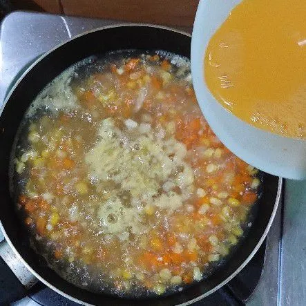 Kemudian ketika air mendidih tambahkan kocokkan telur dan aduk hingga rata.