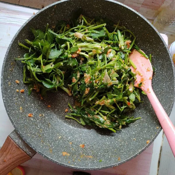 Masukkan daun eceng yang sudah diiris dan dicuci bersih, aduk merata hingga layu.