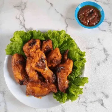 Ayam bakar khas Padang dengan selada sebagai pelengkap