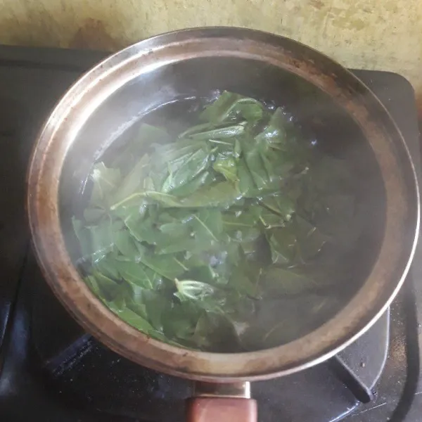Rebus daun singkong lalu tiriskan.