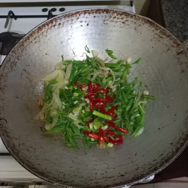 Masukkan irisan bawang daun dan cabe merah keriting, masak hingga matang.