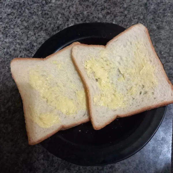 Olesi salah satu bagian roti dengan margarin, ratakan.