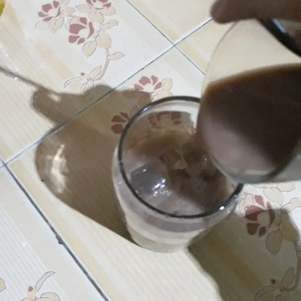 Tuang seduhan bubuk cokelat, lalu beri topping susu kental manis cokelat dan bubuk cokelat. Aduk rata dan sajikan.