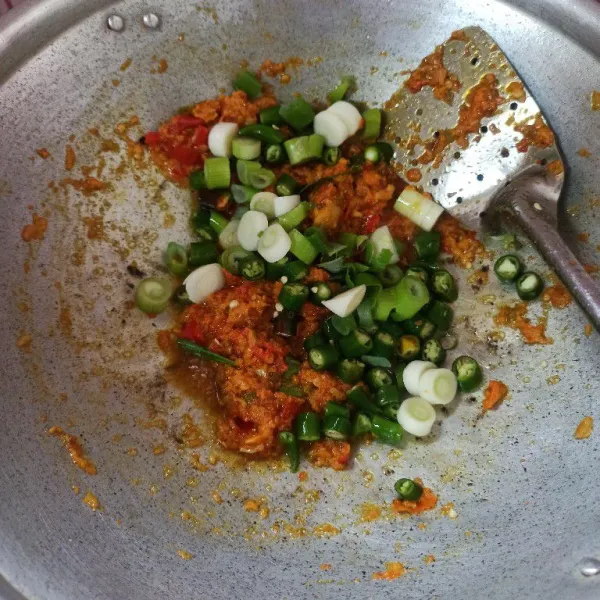 Setelah bumbu matang masukkan daun bawang dan cabai hijau aduk dan masak hingga layu.
