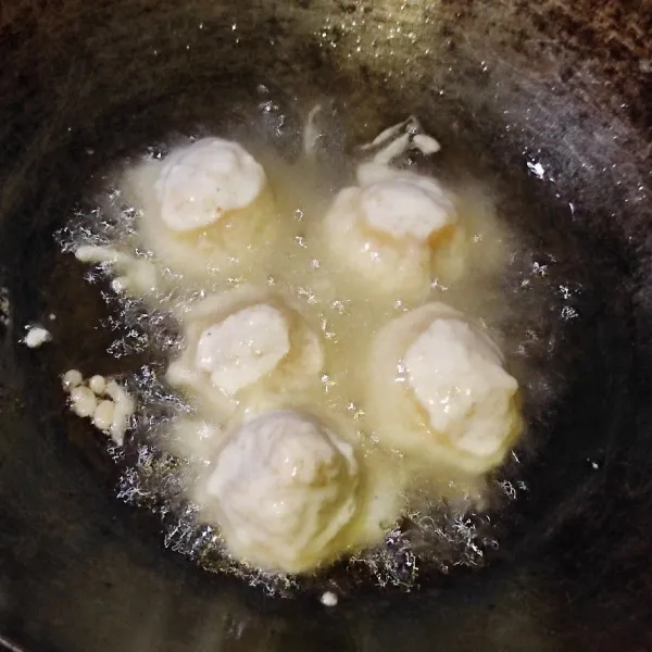 Celupkan tahu kedalam adonan tepung. Lalu goreng di minyak panas sampai matang.