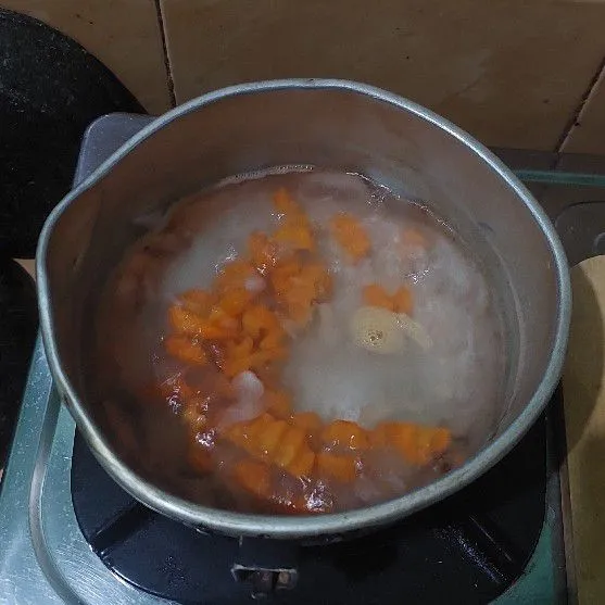 Didihkan air, tambahkan bawang putih kemudian masukkan wortel.